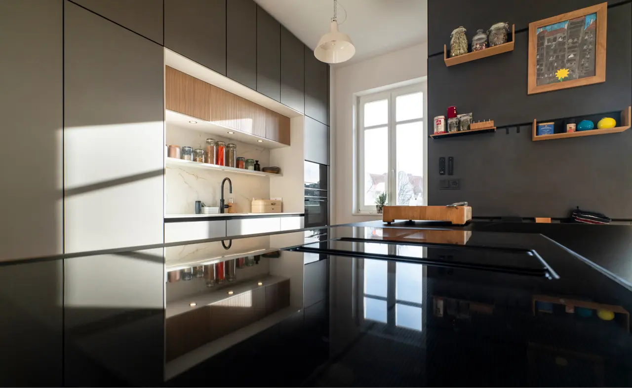 Nahaufnahme einer Tischplatte die die Küche im Hintergrund spiegelt